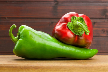 Red and green peppers on wooden board