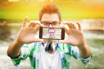 Young hipster man with headphones taking a selfie