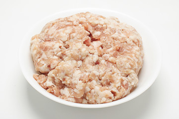 Minced pork meat in the white bow on the white background