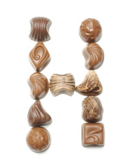 Alphabet letter H arranged from chocolate sweets isolated