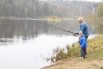 Grandfather and grandson are fishing