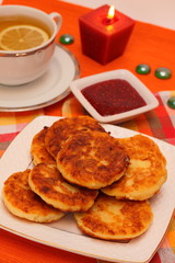 Curd cheese cakes and tea with lemon for breakfast