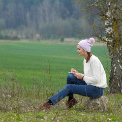 Naklejka na ściany i meble Ordinary hipster girl writing in a notebook outdoors