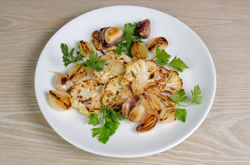 Warm appetizer of fried pieces of cauliflower with garlic and on