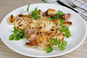 Warm appetizer of fried pieces of cauliflower with garlic and on