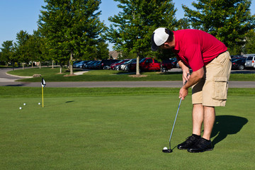 Obraz premium Golfer practicing putting golf balls