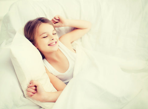 Smiling Girl Child Waking Up In Bed At Home