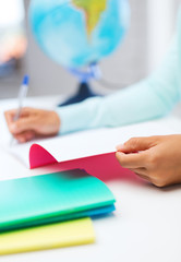 close up of young woman writing in workbook