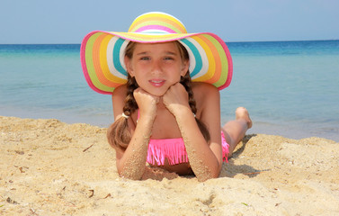 Girl with colorful hat on the beach