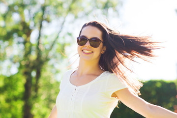 smiling young woman with sunglasses in park