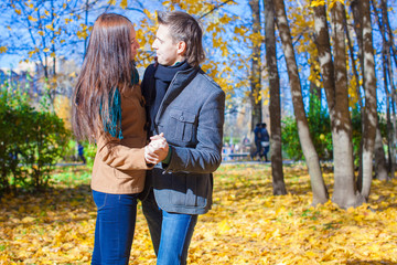 Young couple in autumn park on a sunny fall day