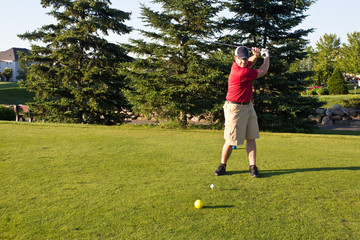 Golfer hitting the ball on the tee