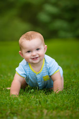 Summer portrait of happy baby boy infant outdoors at park