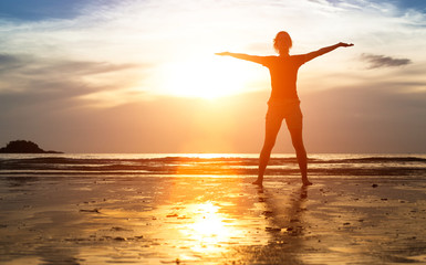 Fototapeta premium Silhouette of woman exercise on the beach at sunset.