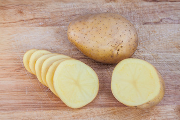 Potato on wooden chopping board