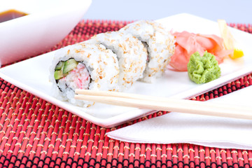 Sushi rolls with sticks and plate