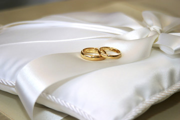 wedding rings on white pillow
