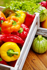 Colorful peppers in a wooden box