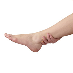 Acute pain in ankle. Woman holding hand to spot of ankle-aches.