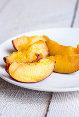 peach slices on white round plate, vertically