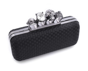 Black handbag brass knuckles and a skull on a white background