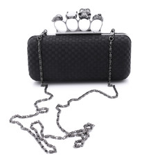 Black handbag brass knuckles and a skull on a white background