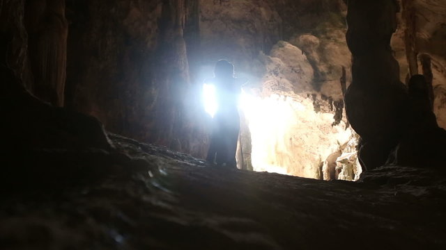 a woman walks into a cave