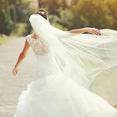 Fototapeta na wymiar happy brunette bride spinning around with veil