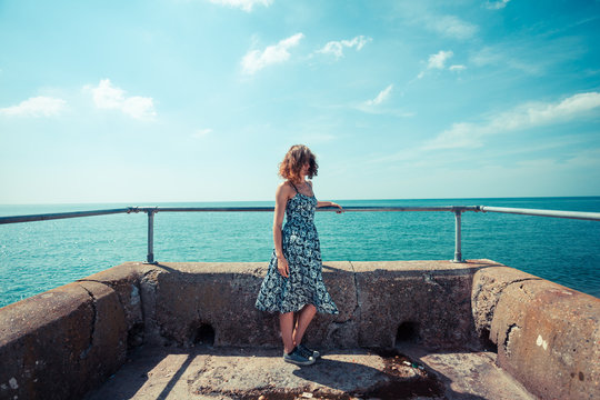 Young woman on a pier by the ocean