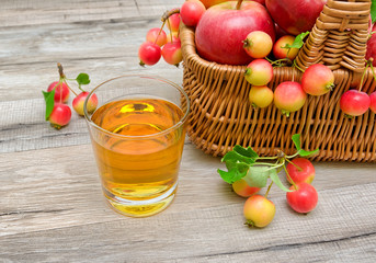 glass with juice and apples in a basket