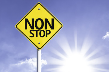 Non Stop road sign with sun background