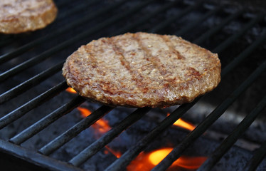Burgers Cooking Over Flames On The Grill