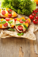 Tasty bruschetta with tomatoes, on old wooden table