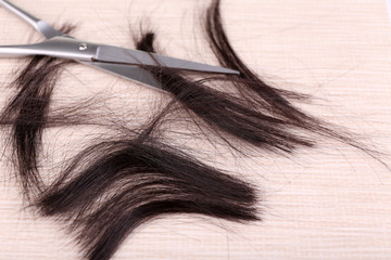 Cut hair and scissors on tile background
