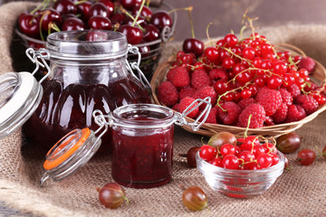 Berries jam in glass jar on table, close-up