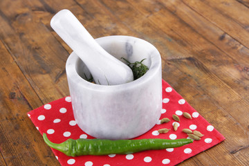 Mortar pounder of estragon on a napkin on a wooden background