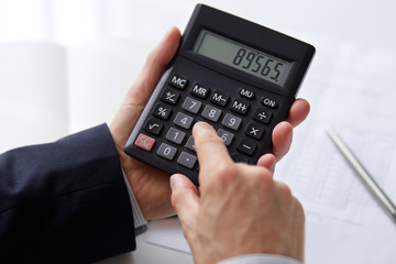 Men's hands with calculator