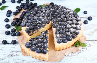 Tasty homemade pie with blueberries on wooden table