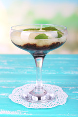 Melon smoothie in glass on table on bright background
