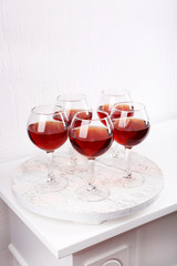 Glasses of wine on tray in room