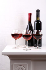 Glasses and wine bottle on table in room