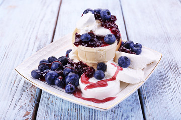 Tasty dessert with fresh blueberries on wooden table
