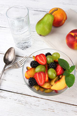 fresh tasty fruit salad on wooden table
