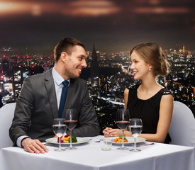 smiling couple eating main course at restaurant