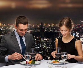 smiling couple eating main course at restaurant