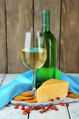 Wine, cheese and crackers on wooden table close-up