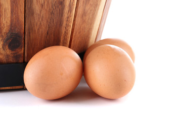 Wooden basket and eggs isolated on white