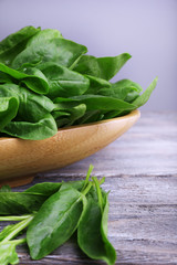 Tuft of fresh sorrel in wooden plate on wooden background