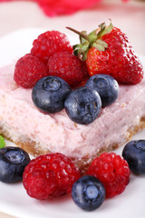 Cake with fruits and berries on plate on wooden background