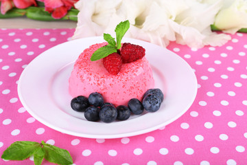 Round shaped cake with berries on plate on polka dot table